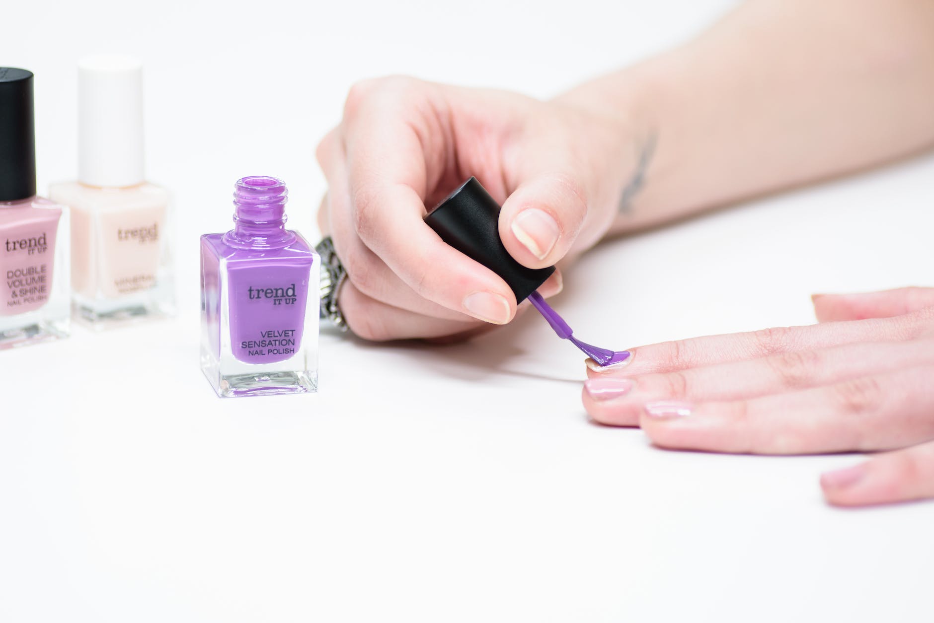 a person using purple nail polish